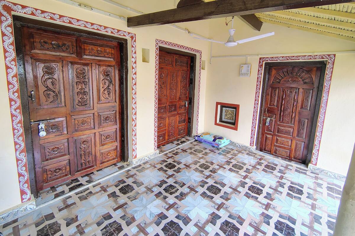 Un couloir doté de portes en bois richement décorées et d’un sol carrelé aux motifs élaborés.