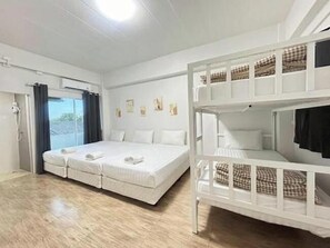 A room with a bunk bed, a single bed, and a window with curtains. - Comfy Hotels Suvarnabhumi Airport (Bang Phli)