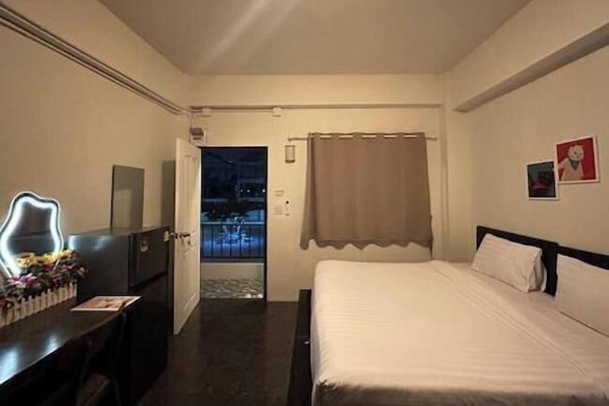 Quarto de hotel com cama, escrivaninha e vista para o exterior.