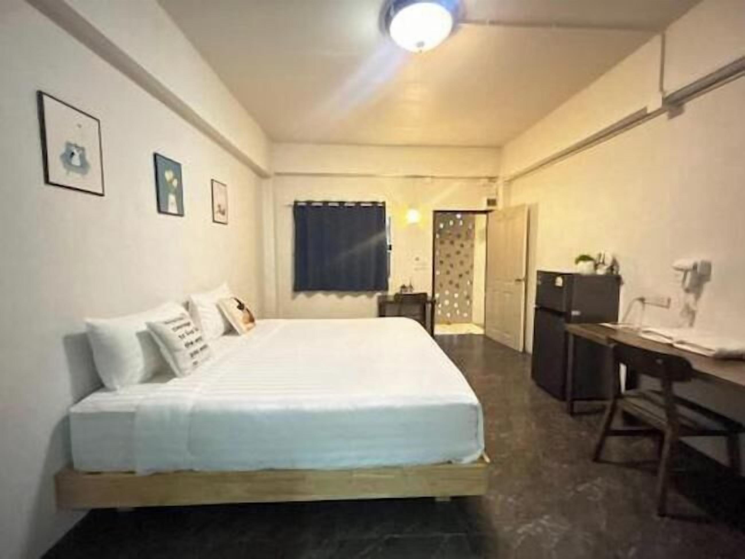 Une chambre à coucher avec un lit, un bureau et une armoire.