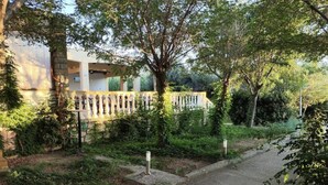 A pathway leading to a building with a stone wall and a row of statues. - Tonino holiday house (Pag)