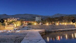 A waterfront hotel with outdoor seating and a pool. - Tonino holiday house (Pag)