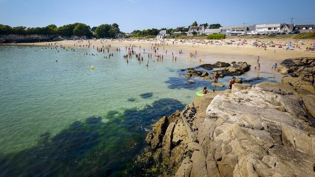 A beach with clear water, rocky shoreline, and beachgoers. - Elegant Breton farmhouse 5 minutes from the ocean, beaches, and town center (Larmor-Plage)