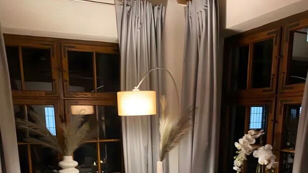 A dining area with a round table, two chairs, a hanging lamp, and a window with curtains. - Apartment 3 in the Heart of Ulm with Wi-Fi (Ulm)