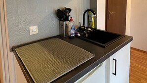 A compact kitchen with a black countertop, a sink, and a cabinet. - Apartment 6 Ulmer Spatz with Wi-Fi (Ulm)
