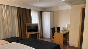 A hotel room with two beds, a desk, a television, and a wardrobe. - Guarulhos Flats Services (Guarulhos)