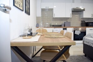 Una cucina moderna con mobili bianchi, un forno a microonde e un forno integrato.