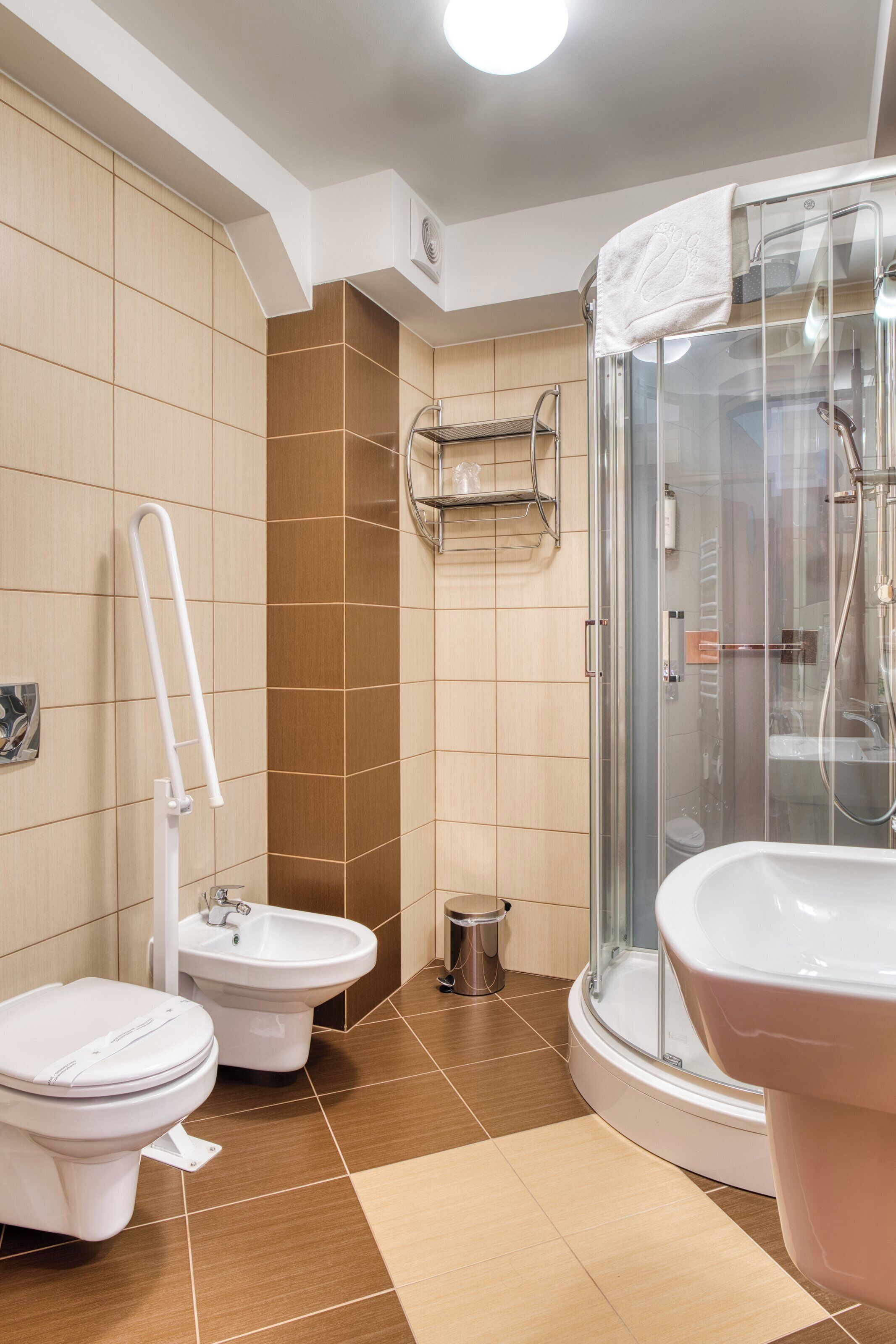 Un baño con inodoro, bidé y zona de ducha.