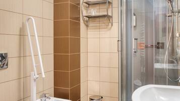 Un baño con inodoro, bidé y zona de ducha.