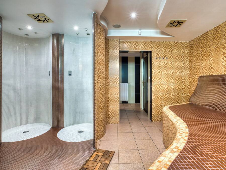 Une salle de bain moderne avec un banc incurvé, un espace douche et un sol carrelé.