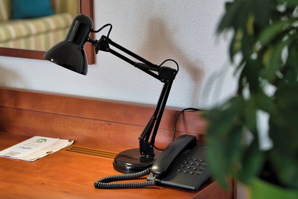 A desk with a telephone and a desk lamp.