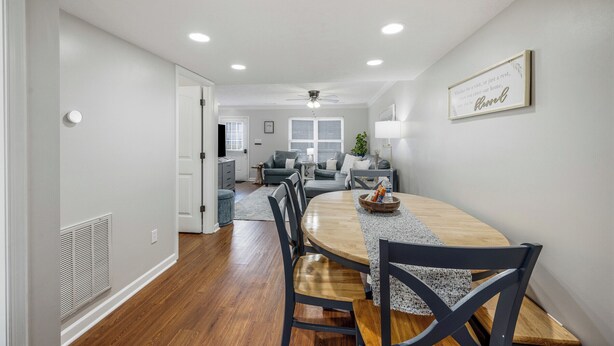 A modern dining area with a wooden table, dark chairs, and a ceiling fan. - Luxury 3BR3BA 2 King Suites 5 Mins-Liberty University Family Friendly Townhouse (lynchburg)