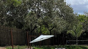 A rectangular swimming pool with a tiled deck, surrounded by a fence and greenery. - Modern house in Serra do Cipó, a peaceful place in an excellent location. (Serra do Cipó)
