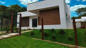 A modern two-story house with a flat roof, large windows, and a well-maintained lawn. - Modern house in Serra do Cipó, a peaceful place in an excellent location. (Serra do Cipó)