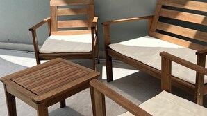 A set of wooden furniture including a bench and two tables, positioned against a plain wall. - Modern house in Serra do Cipó, a peaceful place in an excellent location. (Serra do Cipó)
