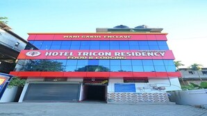 A hotel named "Hotel Tricon Residency" with a red and blue facade, featuring a prominent logo and signage for "Mami Gakul Enclave." - Hotel Tricon Residency (Guwahati)