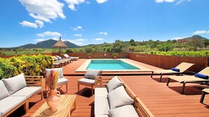 A rooftop pool area with lounge chairs, a small table, and a decorative vase. - Finca Casou | Pollensa | Spacious countryside retreat with pool for. (Pollensa)