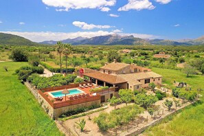 A villa with a swimming pool, surrounded by lush greenery and mountains. - Finca Casou | Pollensa | Spacious countryside retreat with pool for. (Pollensa)