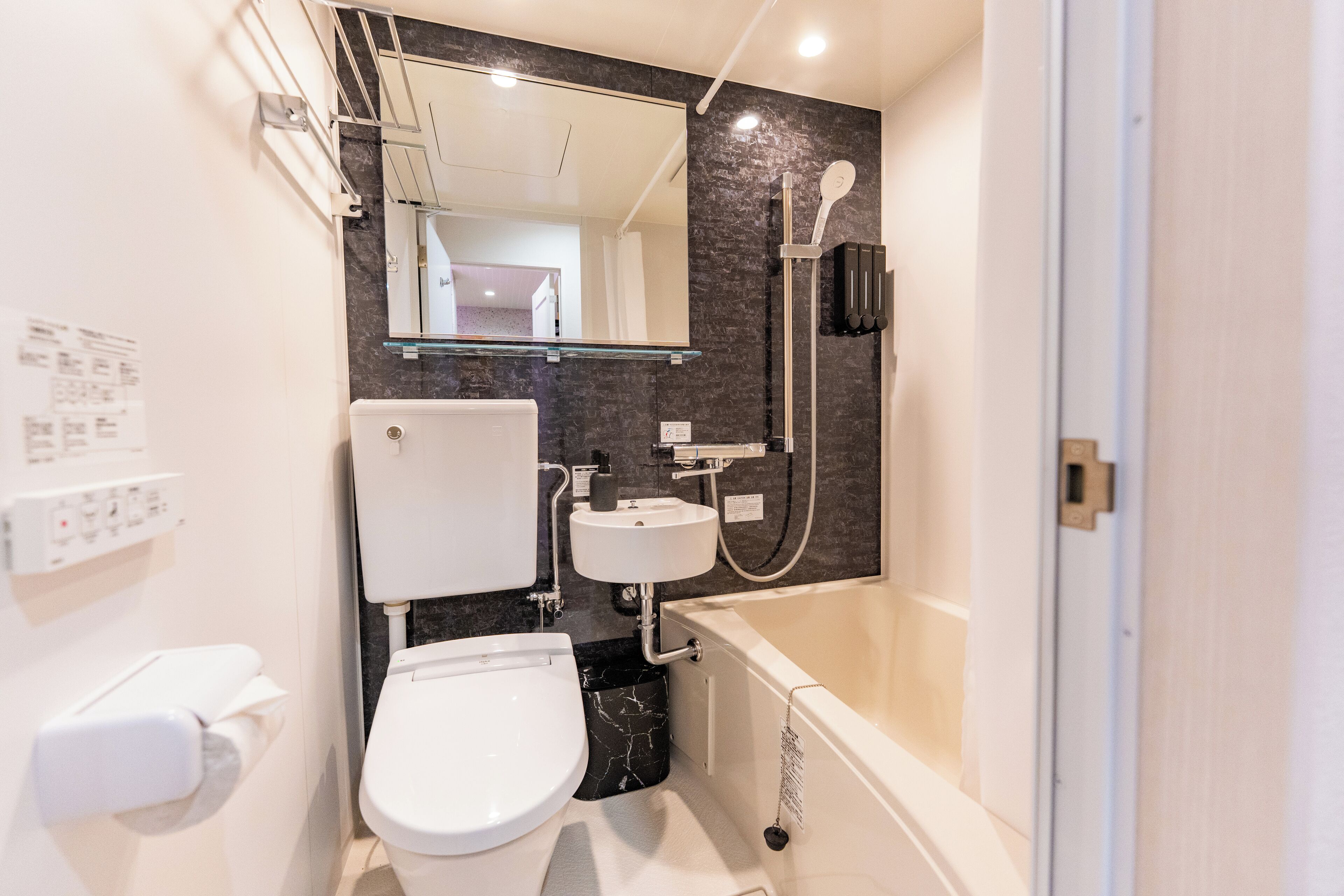 Ein modernes Badezimmer mit Toilette, Waschbecken und Badewanne.