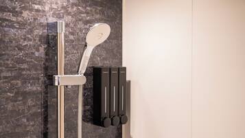 A modern shower with a handheld showerhead and a wall-mounted control panel.