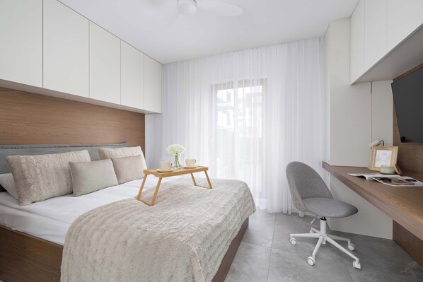 Escritorio, tabla de planchar con plancha, wifi y ropa de cama