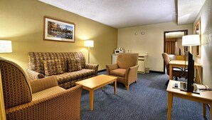A hotel room with a sofa set, a dining table, a chair, a desk with a computer, and a microwave. - Hotel in Millinocket Maine with pool, lounge, food & Snowmobile/ATV trail access (Millinocket)