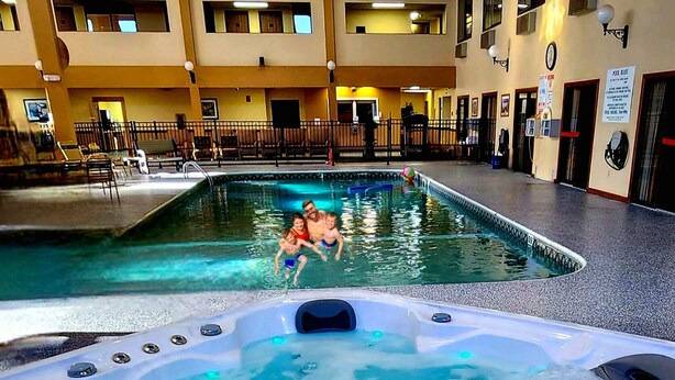 A swimming pool with a hot tub in the foreground. - Hotel in Millinocket Maine with pool, lounge, food & Snowmobile/ATV trail access (Millinocket)