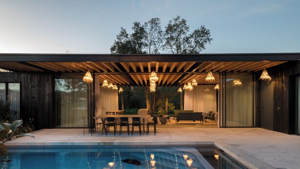 Un área de piscina moderna al aire libre con un pérgola de madera y asientos.