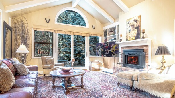 A spacious living room with a fireplace, large windows, and a cozy seating area. - Cozy Ketchum Retreat - A Highly Sought-After, Pet-Friendly Getaway (Ketchum)