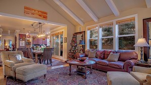 A spacious living room with a fireplace, a large window, and a Christmas tree. - Cozy Ketchum Retreat - A Highly Sought-After, Pet-Friendly Getaway (Ketchum)