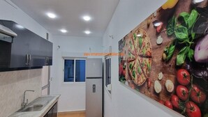 Une cuisine équipée d’un four encastré, d’un évier et d’une fenêtre.