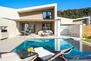 Uma casa moderna com piscina, área de estar externa e cozinha.