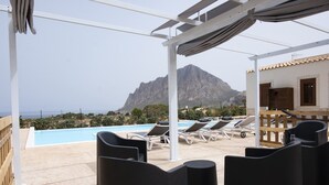 A poolside area with lounge chairs, a pergola, and a mountain view. - Casa Pietra Bianca | Cornino Bay | Modern comfort | Private pool | Sicily (Castellammare del Golfo)