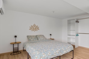 Une chambre à coucher comprenant un lit, des tables de chevet, un élément de décoration murale et une armoire.