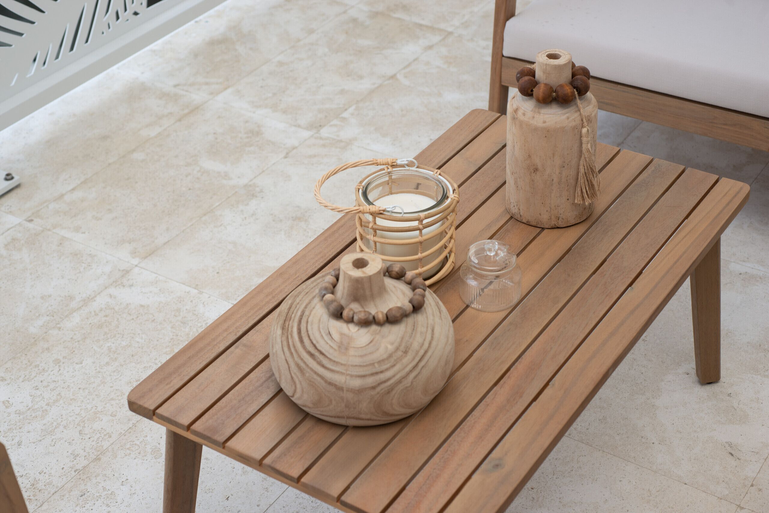 A wooden bench with two ceramic vases and a glass container on it.