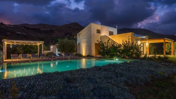 A modern villa with a swimming pool, outdoor seating, and a stone wall. - Casa Maruzza | Scopello | Sea-view retreat with infinity pool (Castellammare del Golfo)