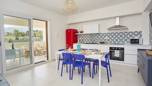 Una cocina moderna con comedor, un refrigerador rojo y vistas al exterior.