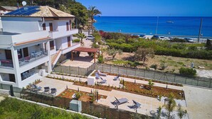Un edificio moderno con panel solar en la azotea, un balcón y vistas al mar.