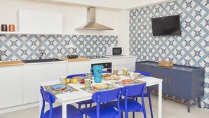 Una cocina moderna con encimera blanca, salpicadero con diseño azul y un mueble oscuro.
