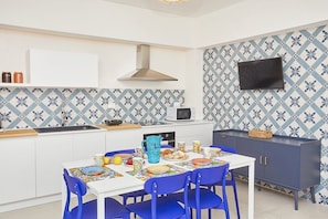 A modern kitchen with a white countertop, blue patterned backsplash, and a dark cabinet. - Appartamento Azzurra di Sicilia (PT) | Castellammare del Golfo | Steps to. (Castellammare del Golfo)