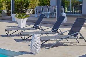 A poolside area with lounge chairs and a decorative white lantern. - Casa Fior di Mandorla | Castellammare del Golfo | Sea View | Infinity Pool (Castellammare del Golfo)