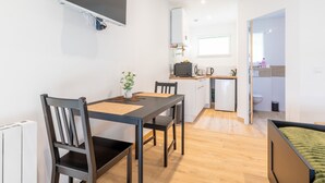 A compact living space with a dining area, kitchenette, and a small bathroom. - New Studio Rivage Garden Floor (Plouédern)