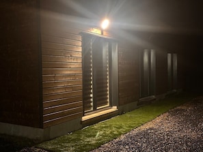 Un bâtiment moderne avec une façade en bois et une entrée illuminée.
