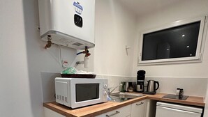 A compact kitchen with a microwave, coffee maker, and dishwasher. - Ancrage New Studio Garden Floor (Plouedern)