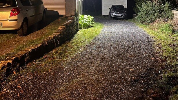 A gravel driveway leading to a garage with a car parked inside. - Ancrage New Studio Garden Floor (Plouedern)