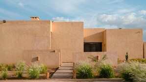 A modern building with a flat roof and a pathway leading to the entrance. - Aggafay experience in Palais Maya (Marrakesh)