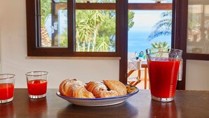 Ett bord med croissanter, två glas röd juice och en kanna med röd juice.