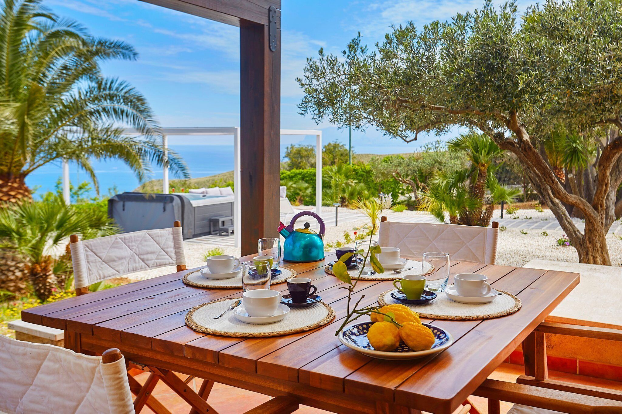 Un espace extérieur aménagé pour les repas, avec une table en bois pour deux personnes, entourée de chaises.
