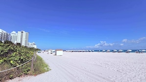 A beach with white sand, a clear blue sky, and buildings in the background. - Art Deco Stay 1 Block From Ocean Balcony (Miami Beach)