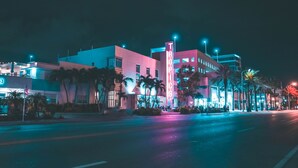 A nighttime view of a modern building with a prominent 'TROPIC' sign, featuring a flat facade and minimalistic design. - Art Deco Escape Steps to Ocean Free Parking (Miami Beach)
